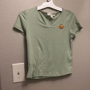 I am selling a green top with a v neck and a smiley face!